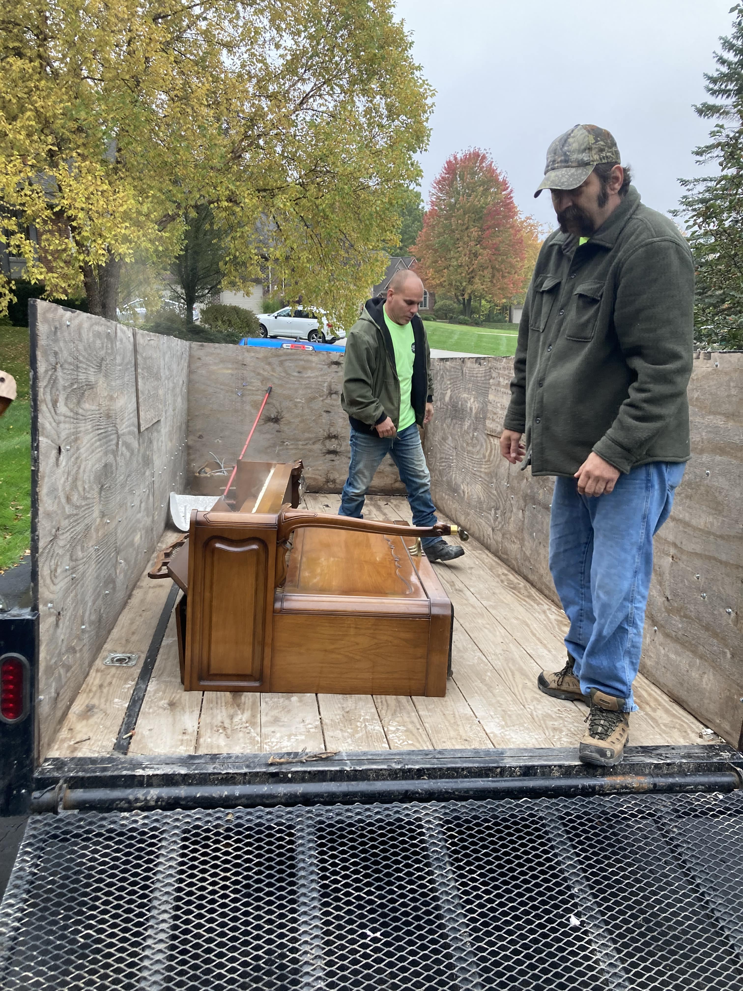 two employees loading a truck with furniture